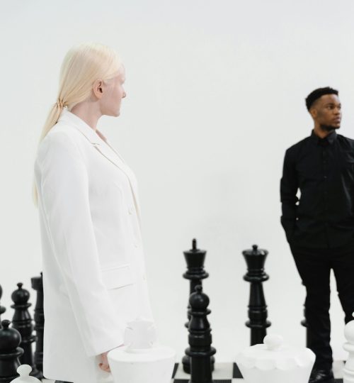 Two adults engage with a life-sized chess set, symbolizing strategy and leadership.